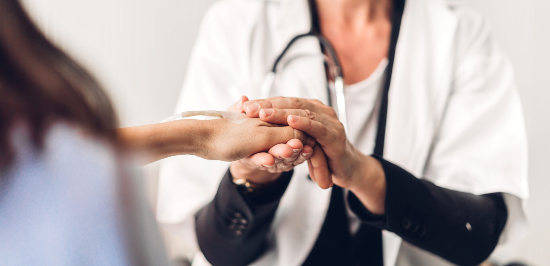 Woman Doctor Consulting And Holding Hand Patient Reassuring With